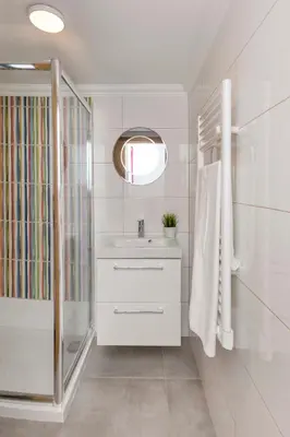 a white bathroom with a sink and a shower at Villa Petala in Albufeira