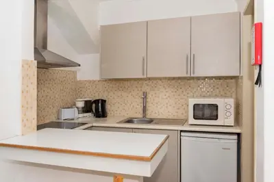 a kitchen with white cabinets and a microwave at Apartment Maresia in Albufeira