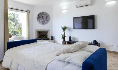 a bedroom with a large bed and a tv on the wall at LongLands Peak at Windmill Hill in Albufeira
