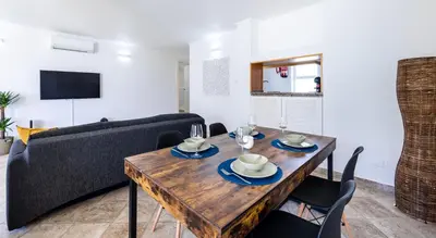 a living room with a wooden table and a couch at LongLands Peak at Windmill Hill in Albufeira