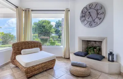 a living room with a chair and a clock on the wall at LongLands Peak at Windmill Hill in Albufeira
