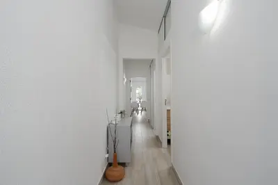 a hallway of a house with white walls and wooden floors at Bright Albufeira - 5min to the beach by LovelyStay in Albufeira