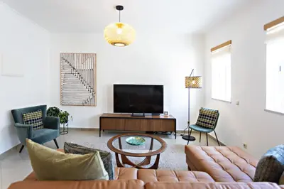 a living room with a couch and a tv at Pink House in Faro