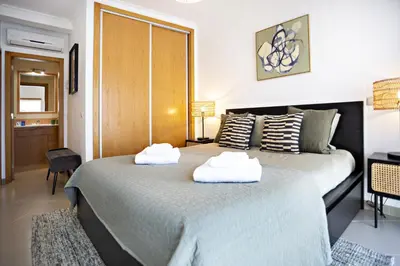 two beds in a hotel room with towels on them at Pink House in Faro