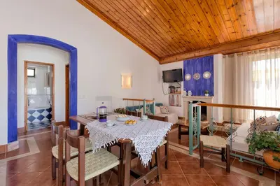 a living room with a table and a couch at Villa Jacaranda in Albufeira