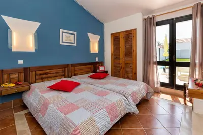 a bedroom with a bed with red pillows on it at Villa Jacaranda in Albufeira