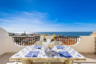 a table with two bottles of wine on a balcony at Oceanview Apartment A by Sequeira in Albufeira
