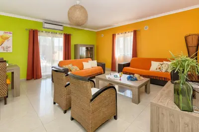 a living room with couches and chairs and a table at Villa Anabela in Albufeira