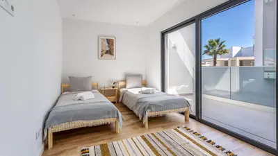 a bedroom with two beds and a large window at Dream Apartment W/Pool & Balcony by LovelyStay in Albufeira