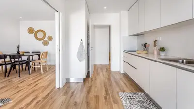 a kitchen and dining room with white cabinets and a table at Dream Apartment W/Pool & Balcony by LovelyStay in Albufeira
