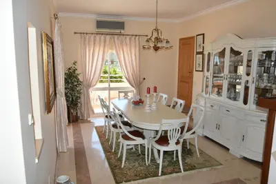 a dining room with a white table and chairs at Villa Malu in Albufeira