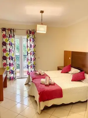 a bedroom with a large bed with red sheets at Candyland Apartment in Albufeira