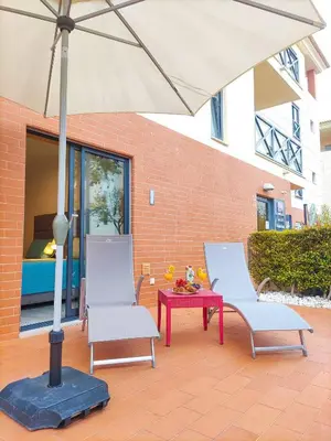 a patio with three wicker chairs and a table with drinks at Luxury Corcovada by BeCherish in Albufeira