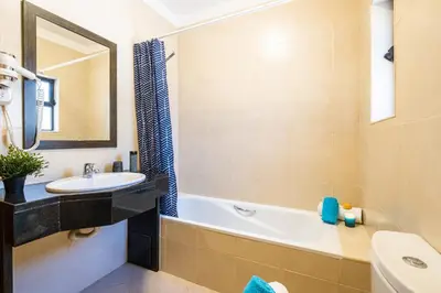 a bathroom with a sink and a bath tub and a mirror at Villa Oasis Del Mar by Algarve Vacation in Albufeira