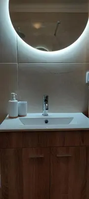 a bathroom sink with a circular mirror above it at Appart Oura Strip in Albufeira
