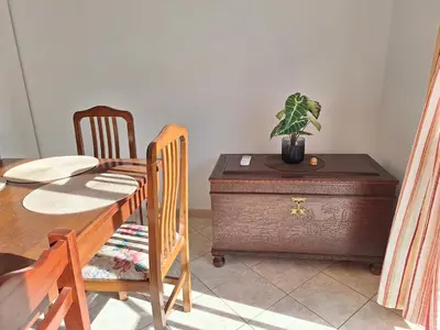 a dining room with a table and a plant on a dresser at Ondasol- acolhedor T2 na cidade velha in Albufeira
