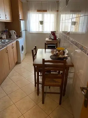 a kitchen with a table and chairs and a sink at Ondasol- acolhedor T2 na cidade velha in Albufeira