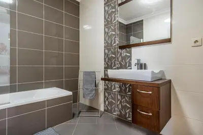 a bathroom with a sink and a tub and a mirror at Villa Casa Vilas Boas in Albufeira