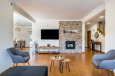 a living room with a fireplace and a tv at Villa Casa Vilas Boas in Albufeira