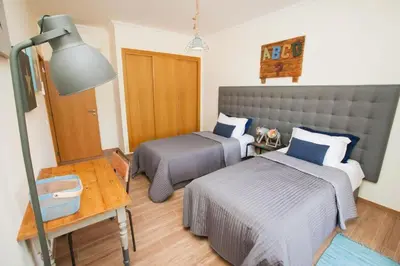 a bedroom with two beds and a desk and a lamp at Jardins da Marina Albufeira in Albufeira