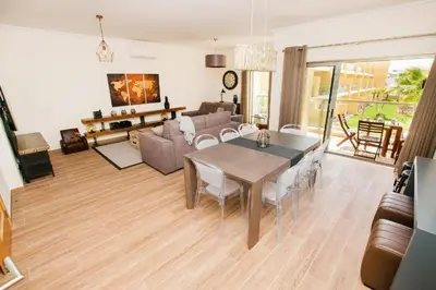 a living room with a table and a couch at Jardins da Marina Albufeira in Albufeira