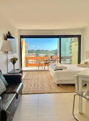 a living room with a couch and a tv at F&V Studio Vilamoura in Quarteira