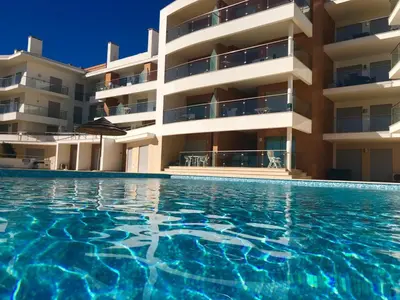 a swimming pool in front of a building at Apartamento Varandas do Mar in Albufeira