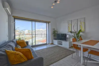 a living room with a couch and a table and a television at Apartamento Varandas do Mar in Albufeira