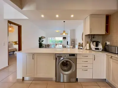 a kitchen with a washing machine in the middle at Vivenda em Vilamoura Marina Ténis Academy in Vilamoura