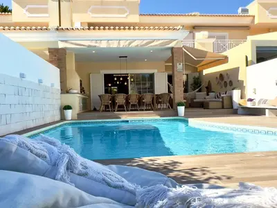 a swimming pool in front of a house at Vivenda em Vilamoura Marina Ténis Academy in Vilamoura