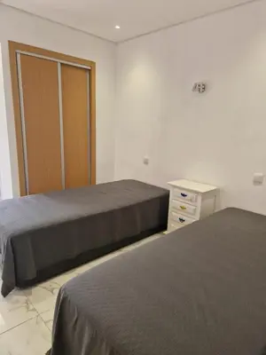 a bedroom with two beds and a dresser and a door at Perfect location for nightlife @ the Strip in Albufeira
