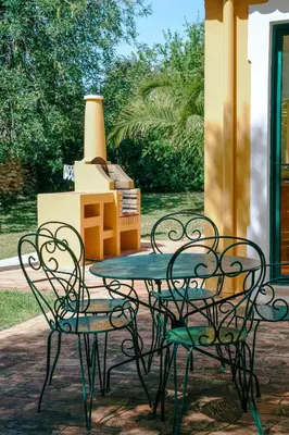 a table and two chairs and a stove at Vila Limão in Boliqueime