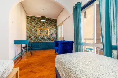 a bedroom with two beds and a blue chair at Happen!ng 2 in Faro