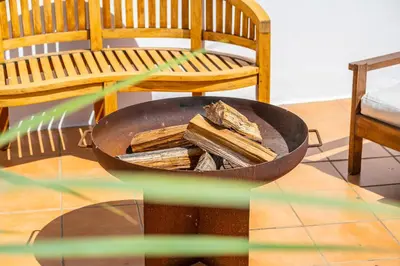 a fire pit with a bench next to a chair at Stunning terrace with ocean view in Albufeira