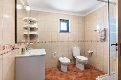 a bedroom with two beds and a wooden cabinet at Villa Trindade in Albufeira