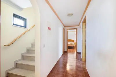 a hallway with a table and a mirror on the wall at Villa Trindade in Albufeira