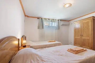 a bedroom with a bed and a red wall at Villa Trindade in Albufeira