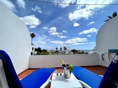 a balcony with blue chairs and a view of the ocean at Albufeira Sunset With Pool by Homing in Albufeira