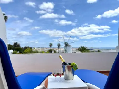 a table with a bottle of wine and a glass at Albufeira Sunset With Pool by Homing in Albufeira