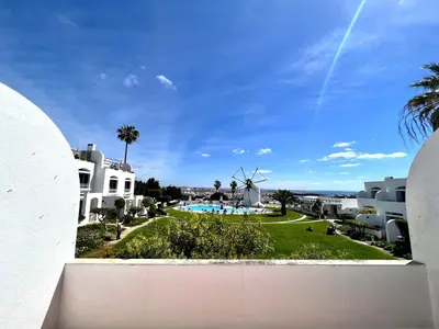 a view from the balcony of a resort with a windmill at Albufeira Sunset With Pool by Homing in Albufeira