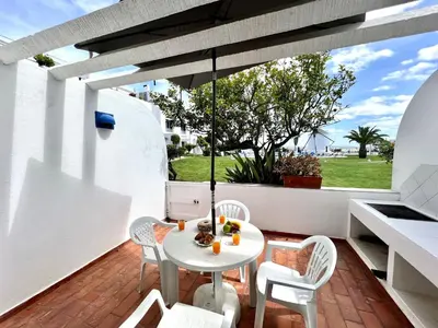 a patio with a white table and chairs on a balcony at Albufeira Sunset With Pool by Homing in Albufeira