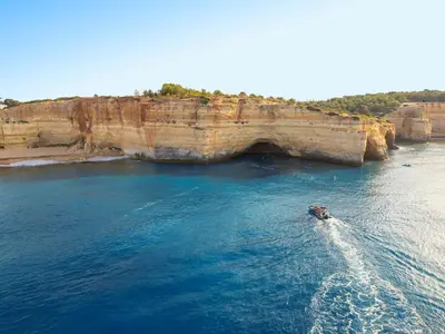 a boat in the water next to a cliff at Villa Isis by Algarve Vacation in Albufeira