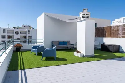 a patio with chairs and grass on a roof at Ocean Blue in Quarteira
