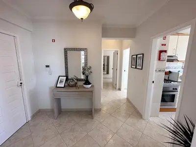 a hallway with a table and a mirror at Ocean Blue in Quarteira