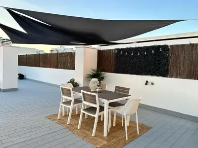 a table and chairs on a patio with a black awning at Ocean Blue in Quarteira