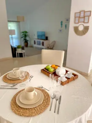 a table with a white table cloth with plates and cups at Detailed Villa - In Vilamoura's Heart in Vilamoura