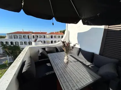 a table and chairs on a balcony with an umbrella at Bela Vista Algarve in Albufeira