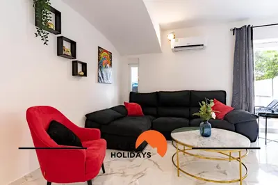 a living room with a black couch and red chairs at #266 Luxurious Villa Bellagio in Albufeira