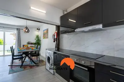 a kitchen with a stove top oven next to a table at #267 Cozy Villa Casablanca in Albufeira