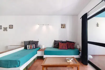 a living room with two beds and a table at Mar Azul 4 in Albufeira